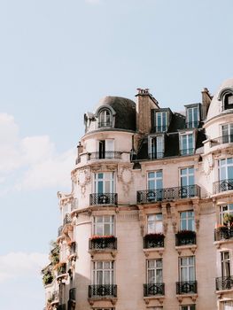 Charming Parisian building showcasing classic architectural design under a clear blue sky.