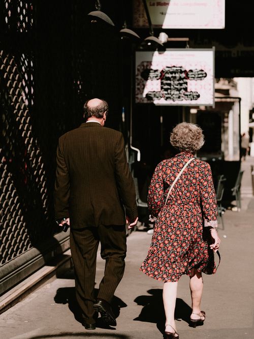 Free Senior couple walking together on a sunlit city street, showcasing love and companionship. Stock Photo