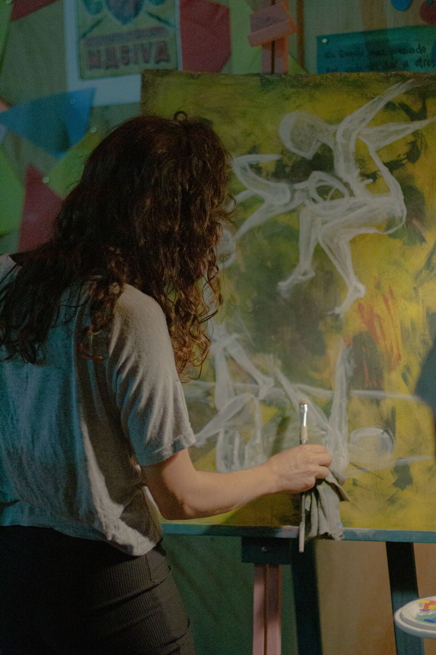 Une artiste travaille au pinceau sur une toile dans son atelier.