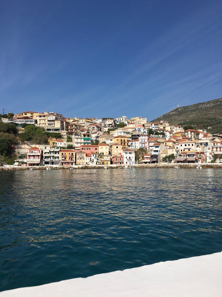 Town Near Body Of Water Under Blue Sky