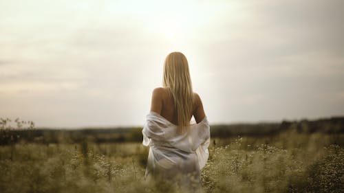Blonde Woman with Naked Back in Meadow