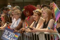 Vibrant scene of people celebrating at the NYC Pride Parade, waving rainbow flags and enjoying the festivities.