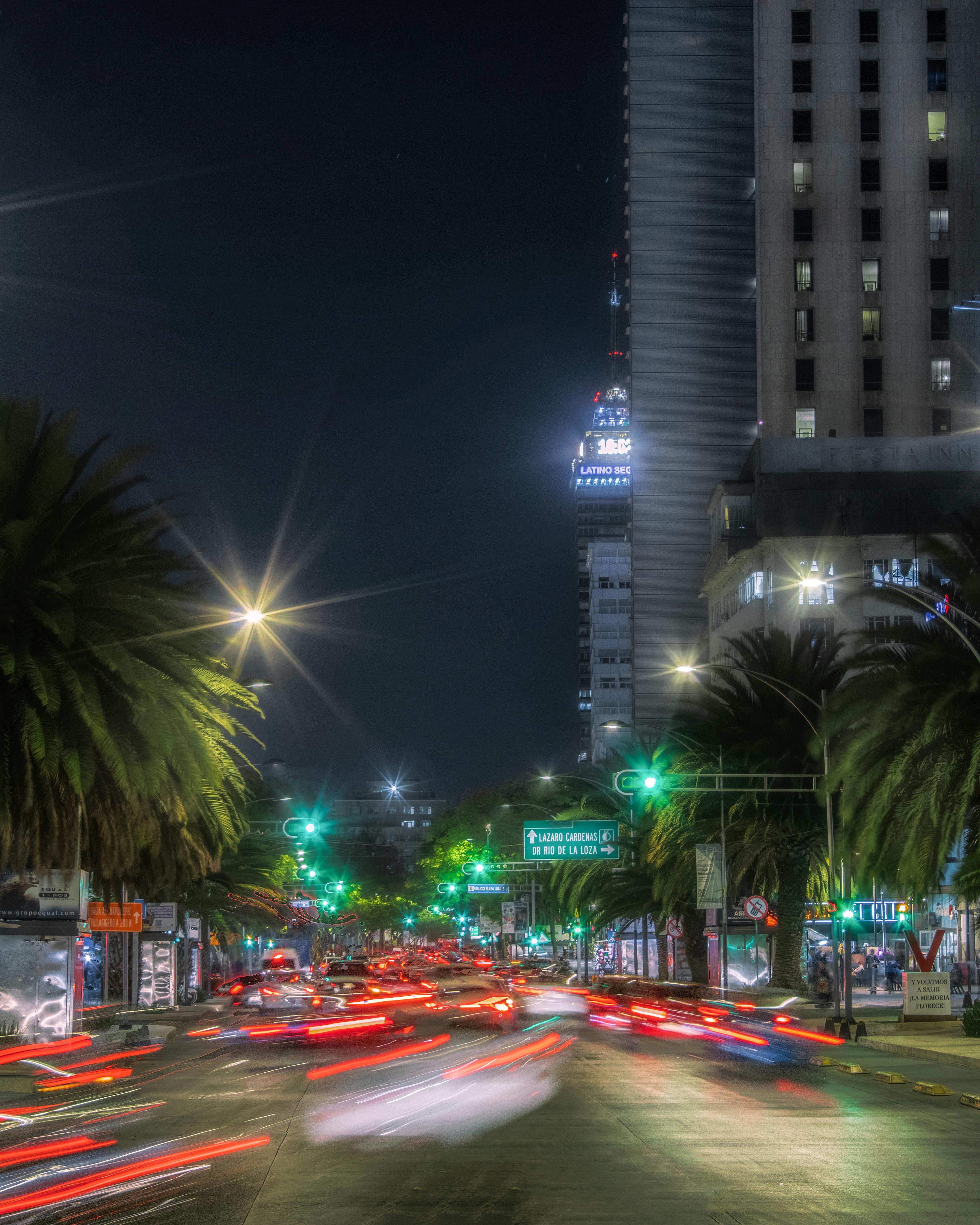 Blurred car lights on a bustling street in Mexico City at night, showcasing urban life and energy.