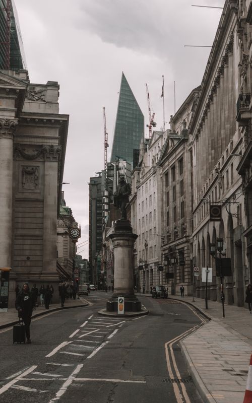 Free An iconic historic street with classic architecture and a towering modern skyscraper in the background. Stock Photo