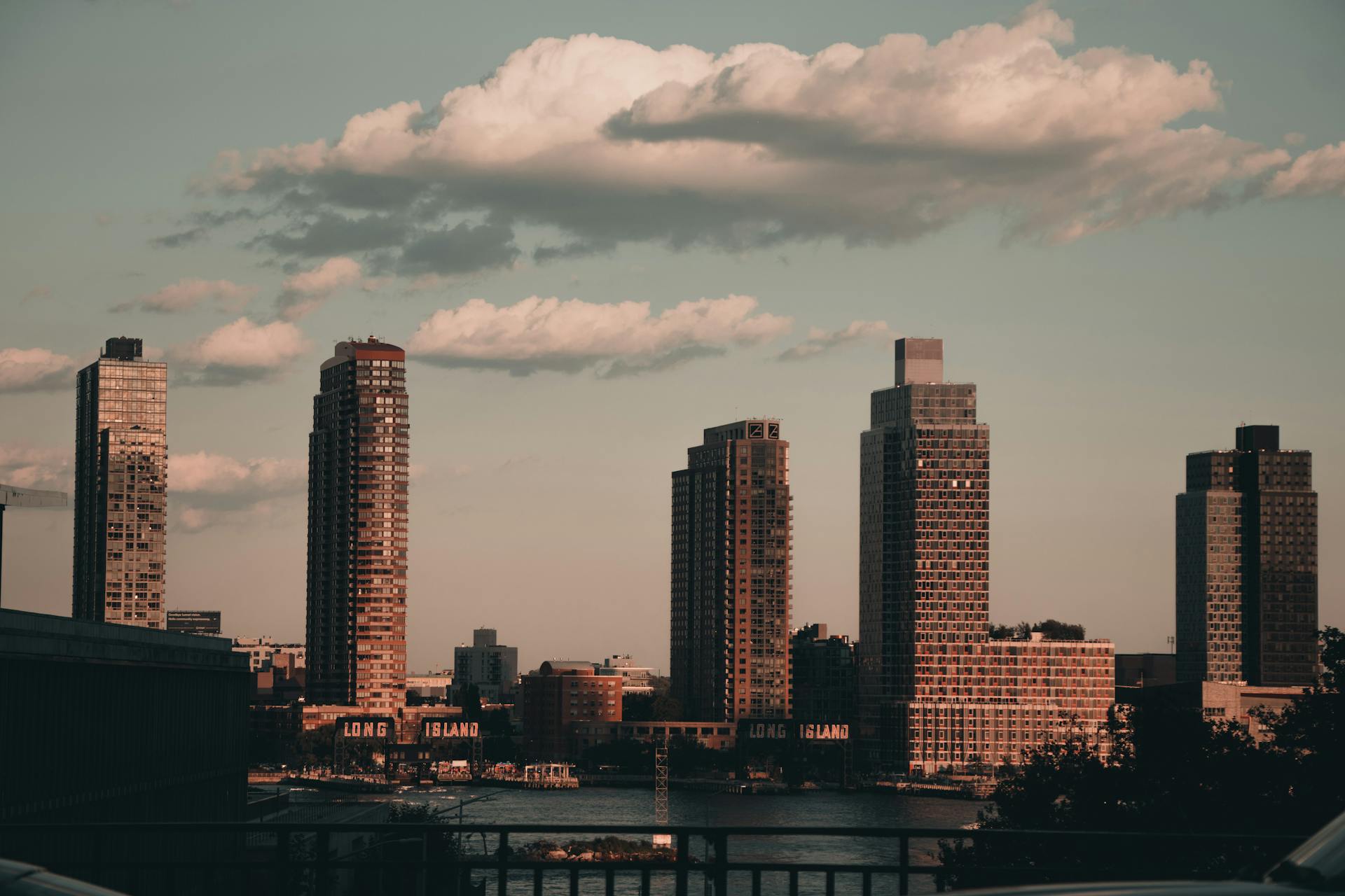 Dramatic urban skyline of Long Island City at sunset with clouds.