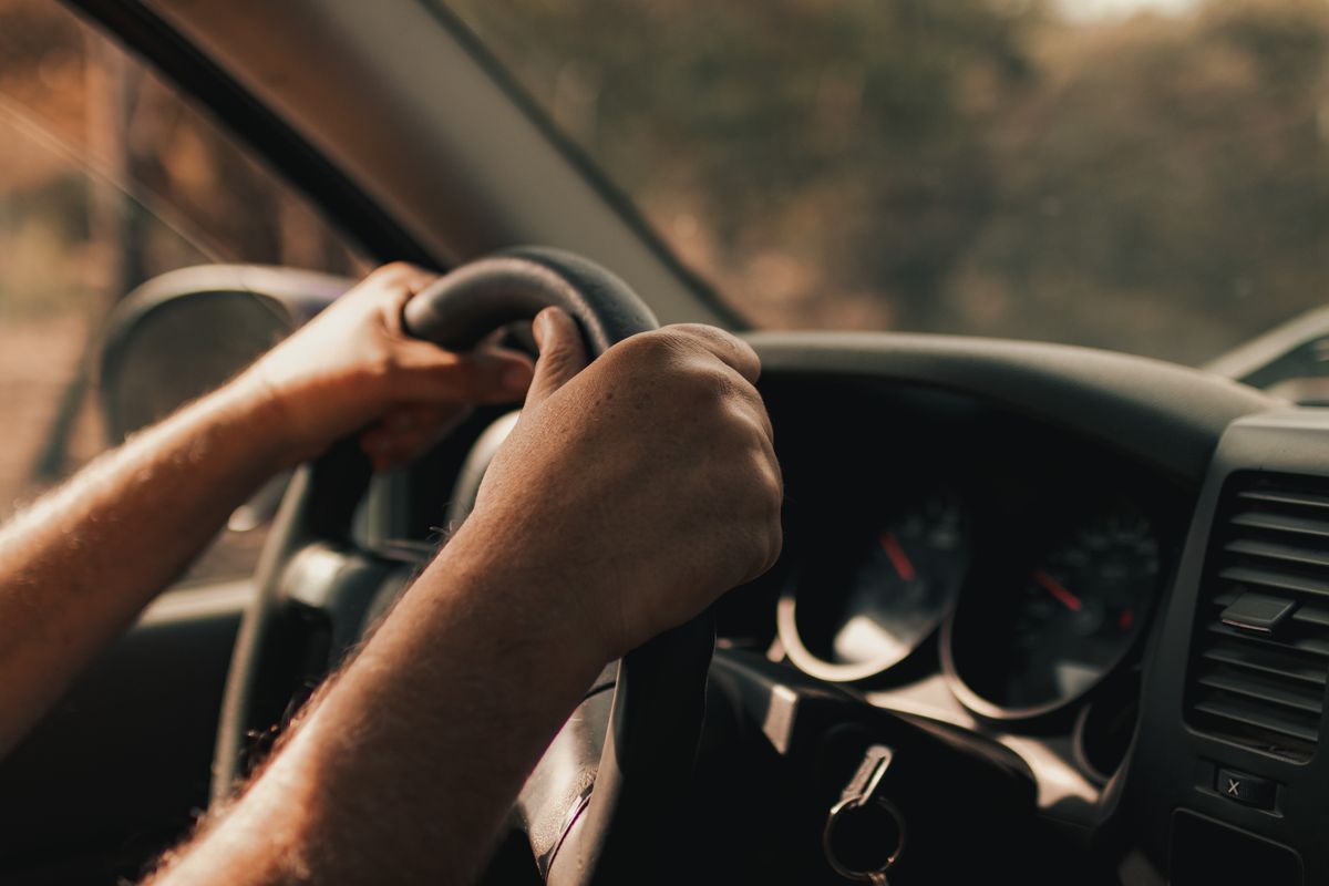 Driver hands on steering wheel — stock photograph Driver’s hands holding a car steering wheel