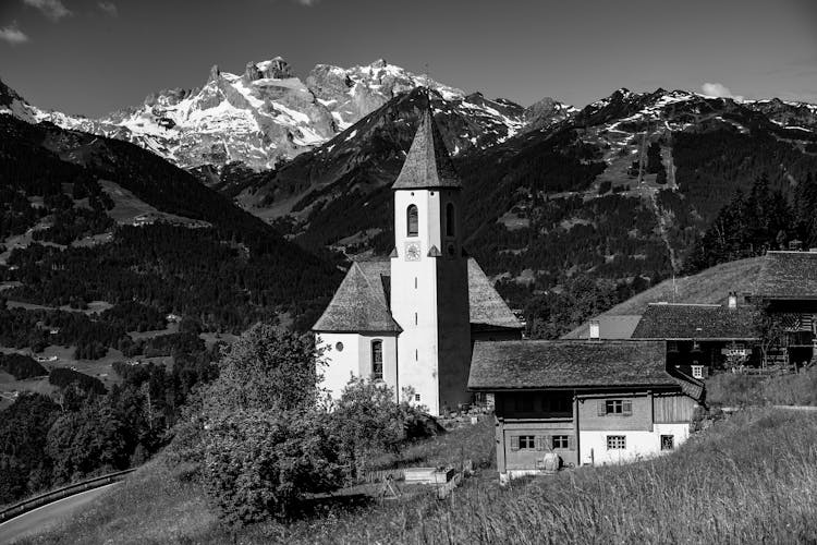 Grayscale Photo Of House Near Mountain