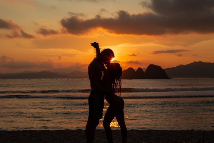 Silhouette Of Kissing Couple On Beach