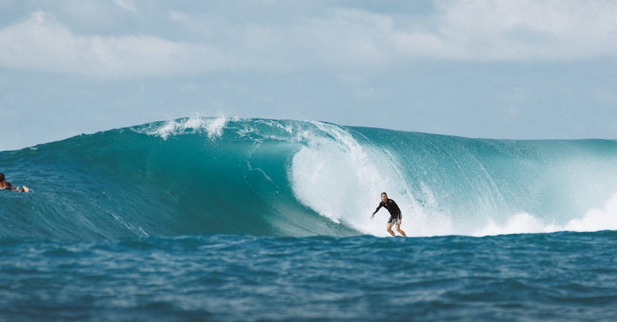 Surfer riding a massive ocean wave in Bali, capturing the thrill and beauty of water sports.