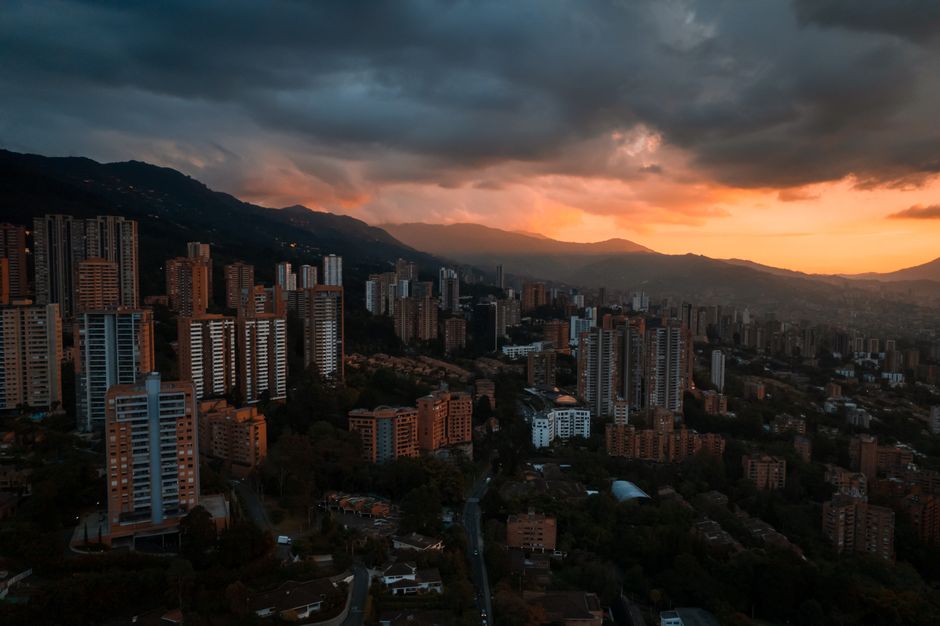 Best The Best Private Tour to Guatapé and Helicopter Ride + Guatapé's Rock + Boat Ride Review 2026 - Stunning aerial view of Medellín's skyline at sunset with dramatic cloud formations creating a moody atmosphere.