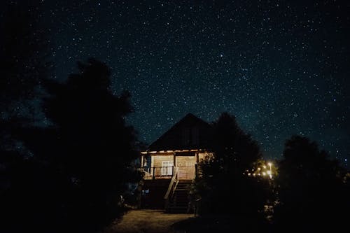 Free Illuminated House Under a Starry Night Sky Stock Photo