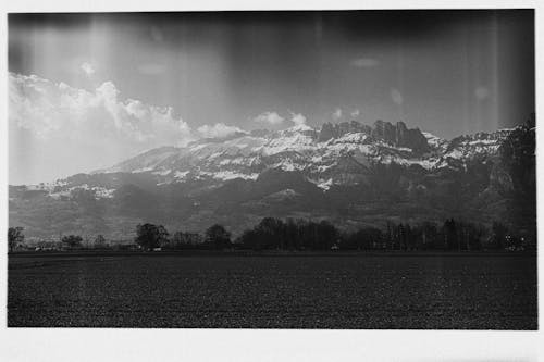 Grayscale Photo of Mountains with Snow