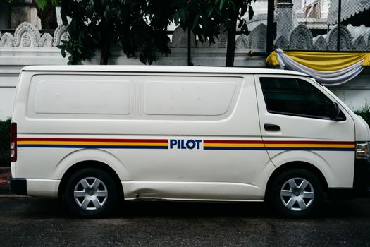 A parked white van with 'PILOT' branding, seen in an urban environment.