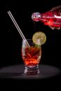 Clear Drinking Glass With Red Liquid and Sliced Lemon