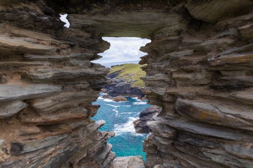 Free Explore the rugged coastline of Tintagel, Cornwall through historic castle ruins framing the sea. Stock Photo