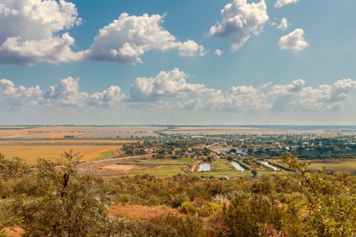 Free Scenic rural landscape with fields, trees, and clouds under a blue sky Stock Photo