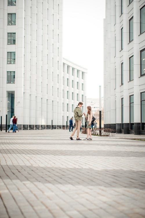 Free Woman and Man Together near Buildings Stock Photo