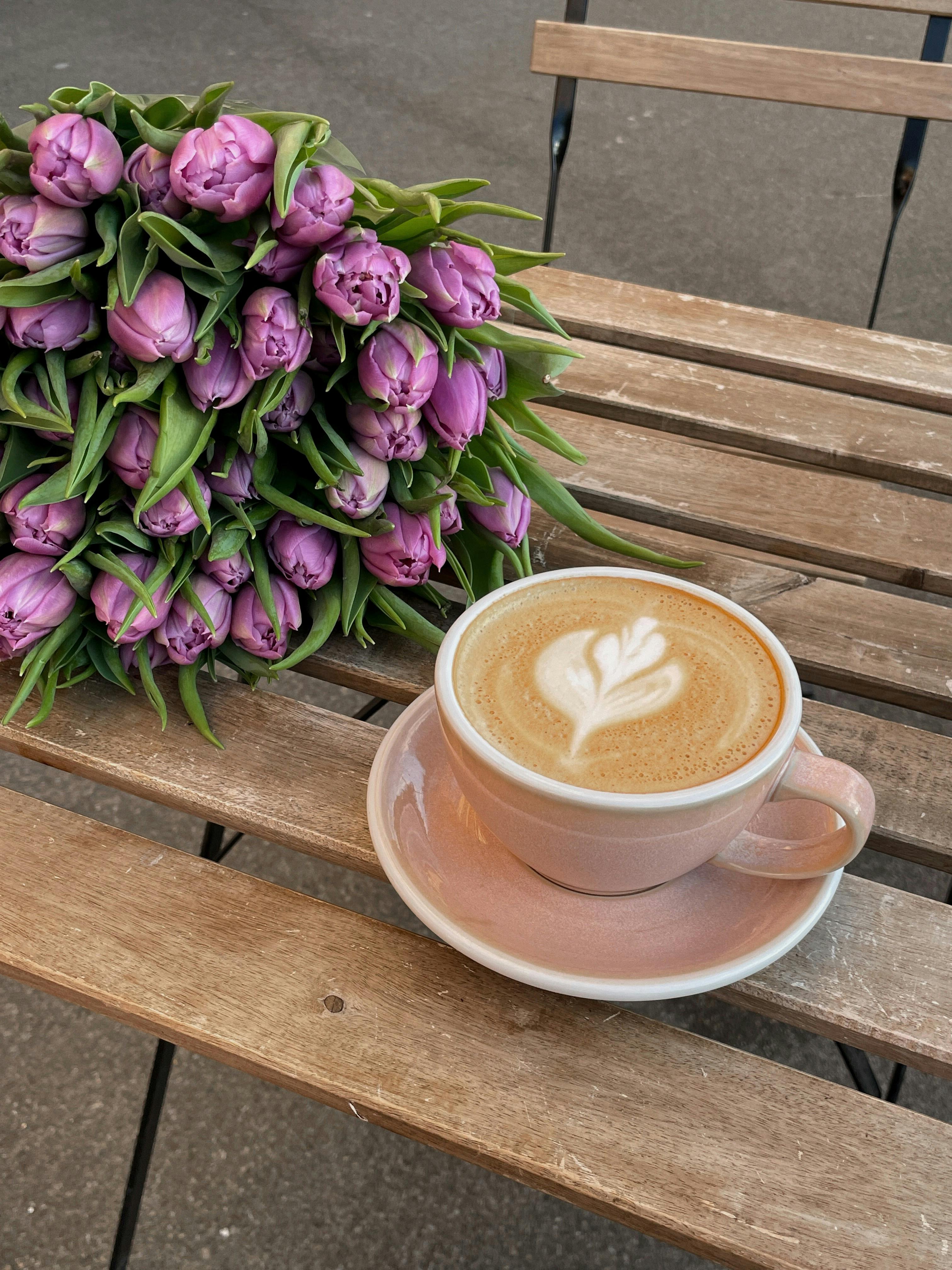 Coffee and bouquet with tulips on the wooden table