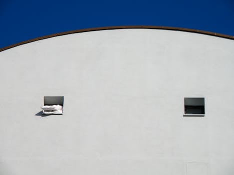 Simple building façade with square windows against a clear blue sky.