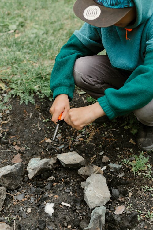 A Person in Green Hoodie Holding a Utility Lighter