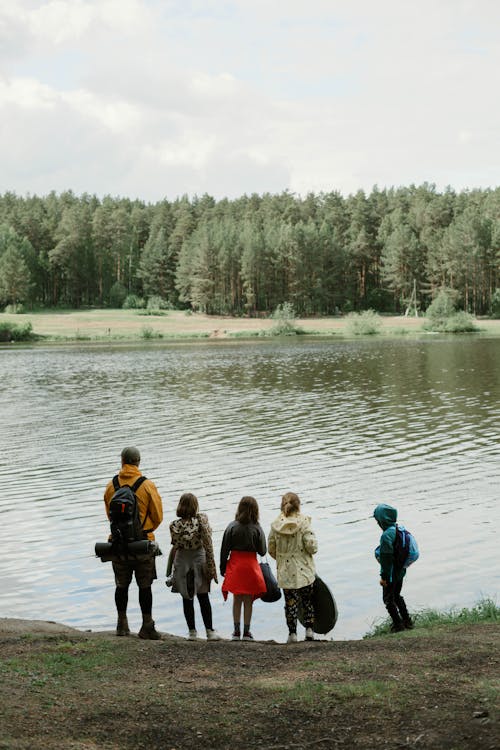 A Group of People Standing Near Body of Water