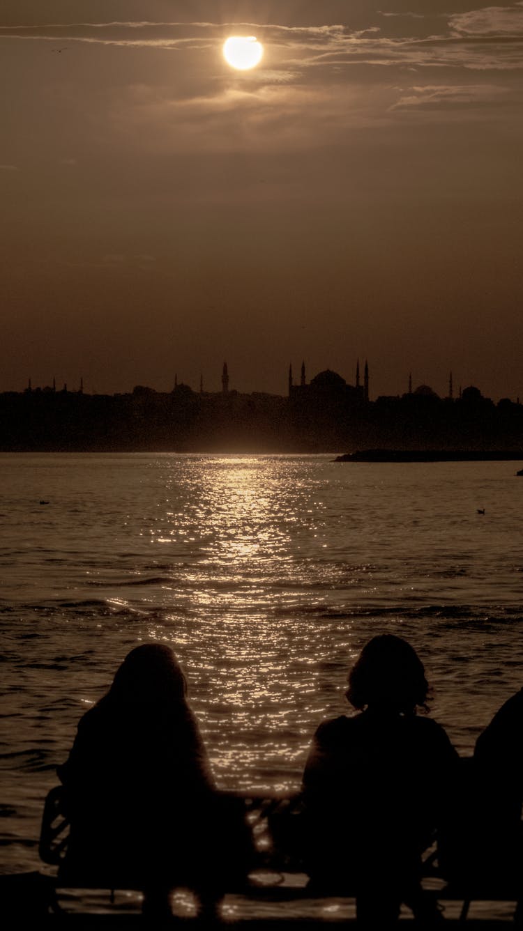 Silhouette Of 2 Person Sitting On The Beach During Sunset