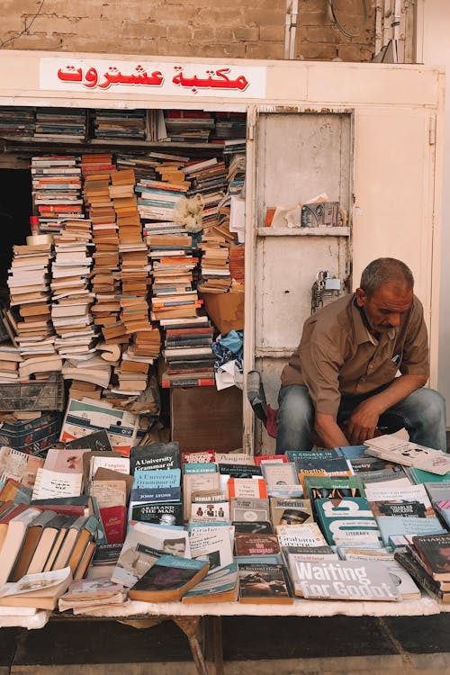 Man Selling Books Lying on Table