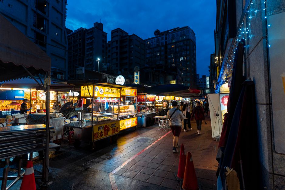 Vibrant night market scene with various street food stalls in Taiwan