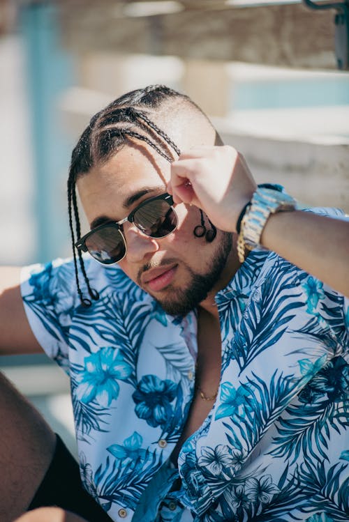 Man in Blue and White Floral Tank Button Up Shirt Wearing Black Sunglasses