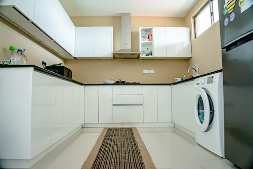 Free Sleek modern kitchen featuring white cabinets, appliances, and minimalist design. Stock Photo