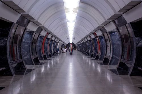 Free Modern underground subway station with clean design, symmetrical arches, and reflective surfaces, creating a futuristic ambiance. Stock Photo