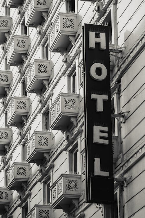 Grayscale Photography of a Signage on a Hotel Building