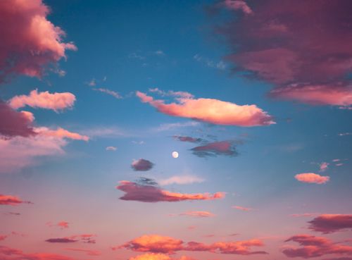 Free Captivating image of pink clouds against a deep blue sky with the moon visible, evoking serenity. Stock Photo