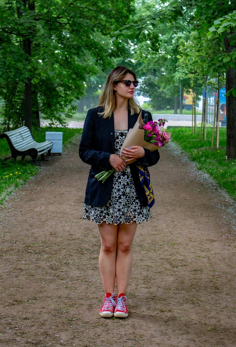 A Woman Holding A Bouquet Of Flowers