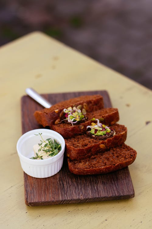 Sliced Bread Beside White Ramekin On Top Of Wooden Platter