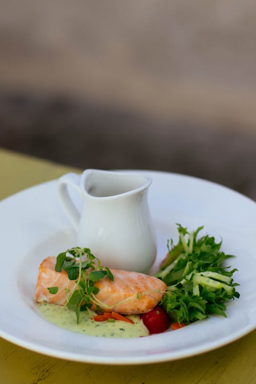 Salmon With Green Vegetable Toppings On White Ceramic Plate