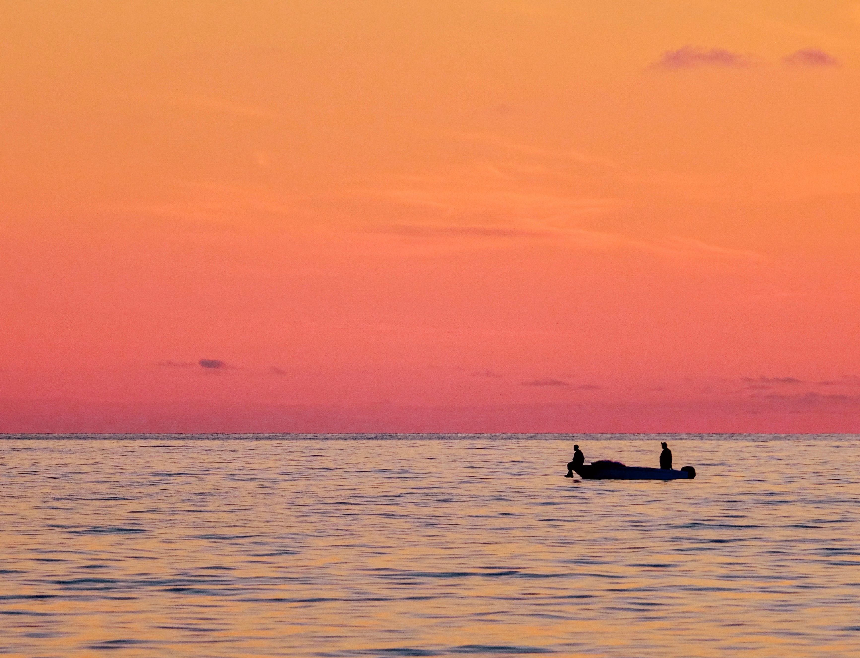 Silhouette of Men on a Boat During Sunset · Free Stock Photo