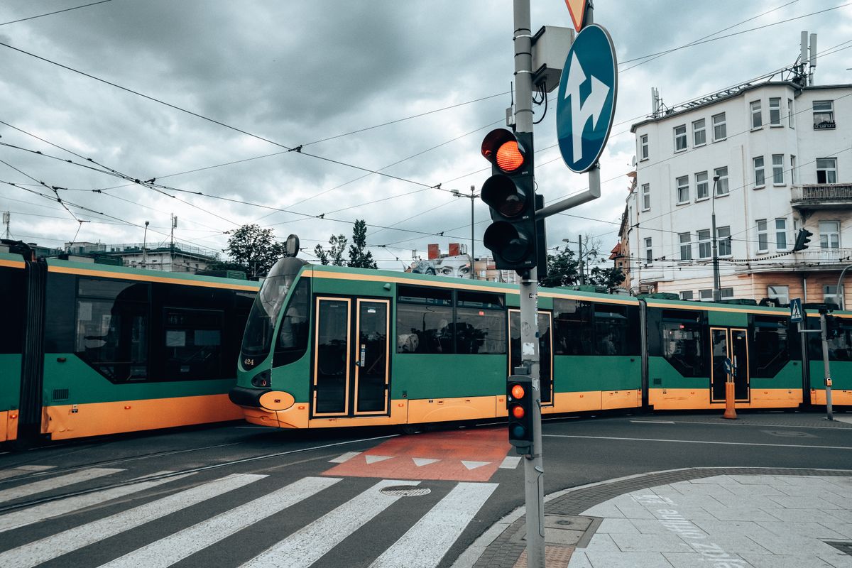 Tram crossing a city intersection under a traffic light — photo by Egor Komarov on Pexels