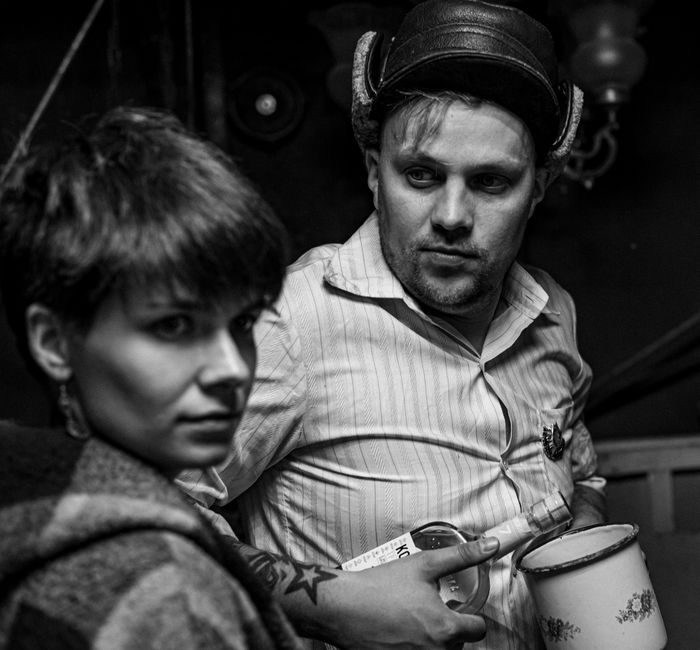Moody black and white portrait of two people indoors, creating a dramatic atmosphere.