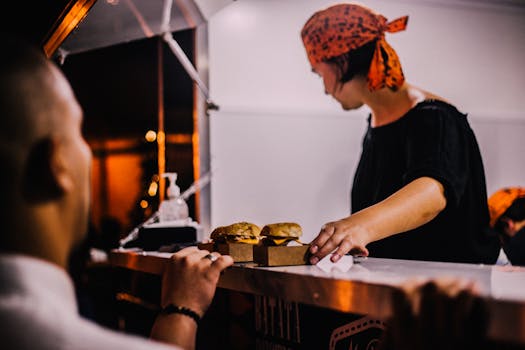 A street vendor in Maceio, Brazil serves burgers at a night market food stall.