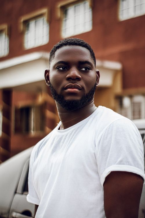 Free Portrait of a bearded man in white shirt against urban Lagos backdrop. Stock Photo