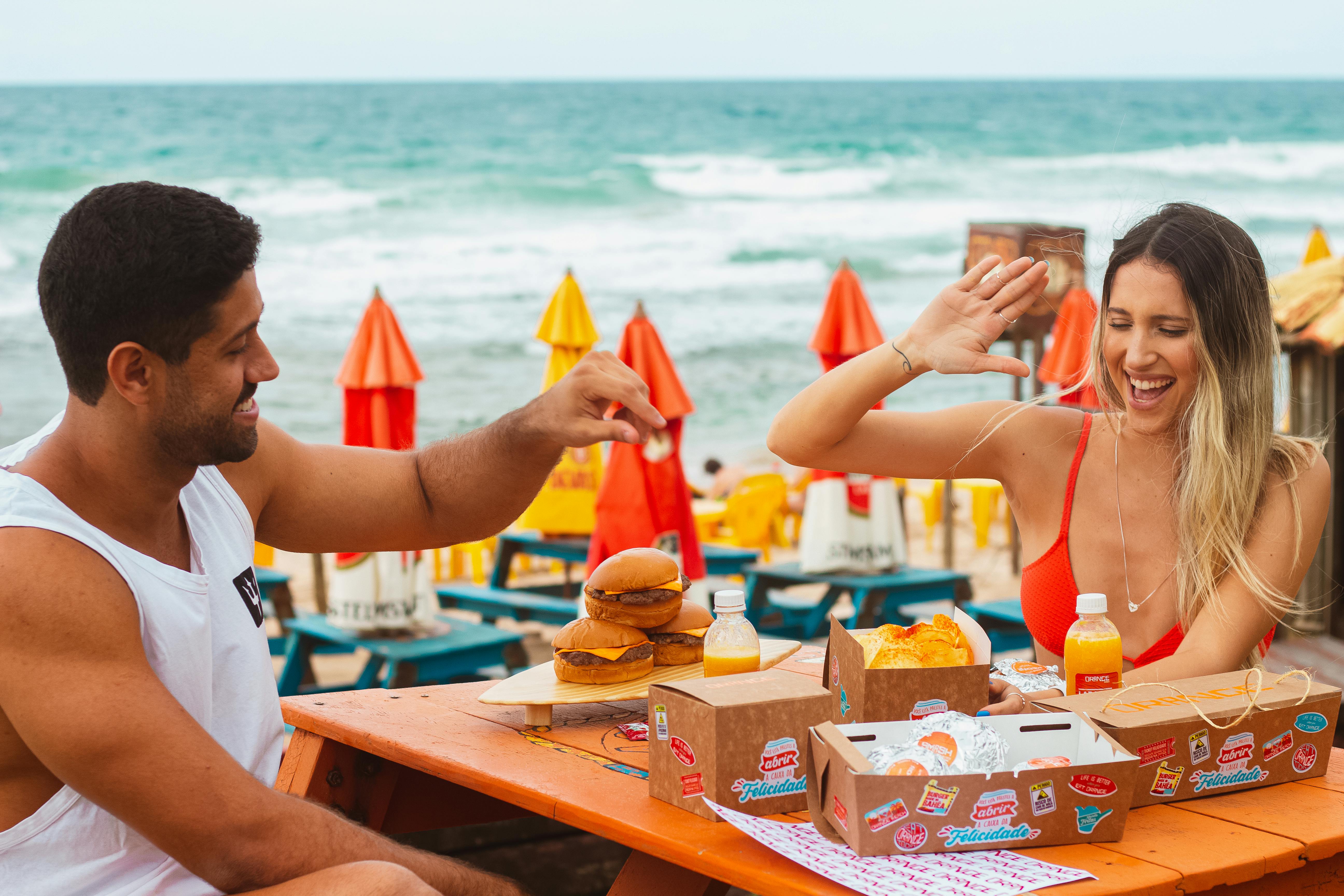 Young Man and Woman Eating in a Beach Bar · Free Stock Photo