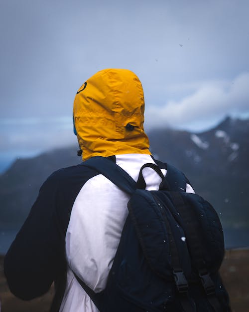 Man Wearing a Jacket Carrying a Backpack