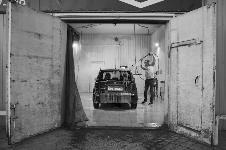 Photo Of A Man Washing A Car In Garage