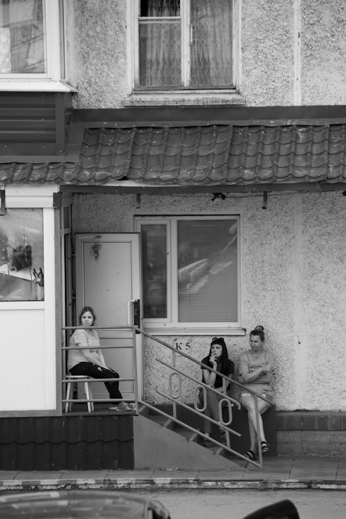 Women Sitting at Entrance of Residential Building