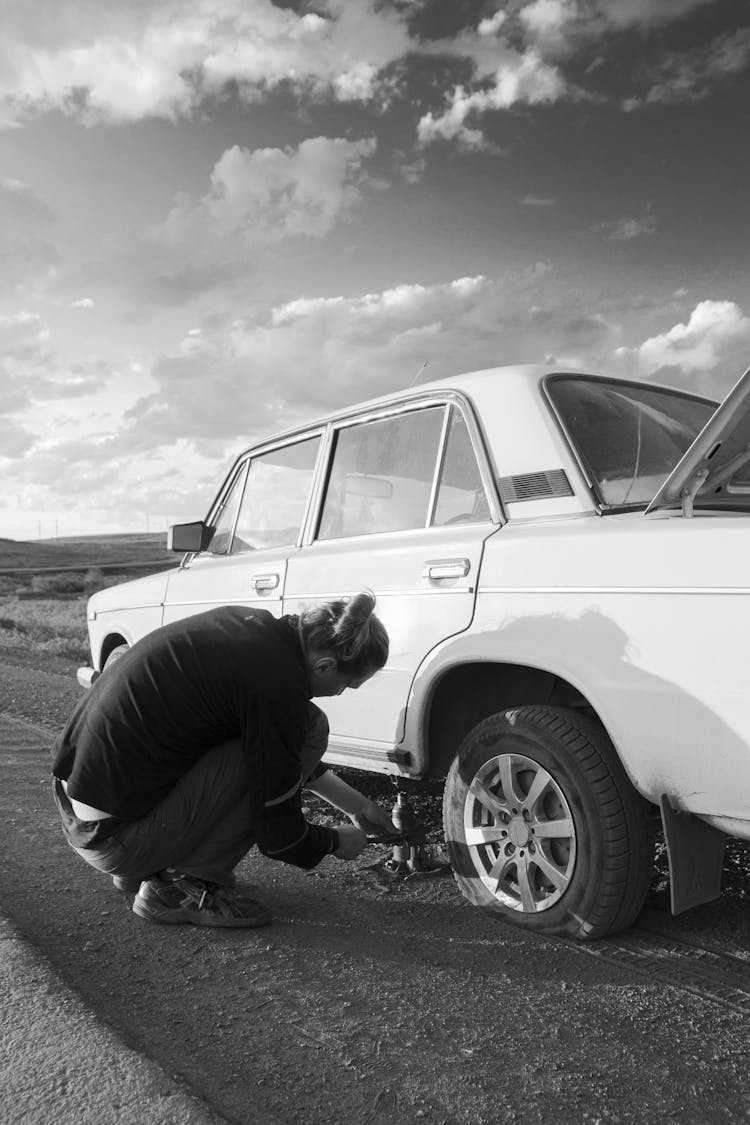 A Man Fixing A Flat Tire