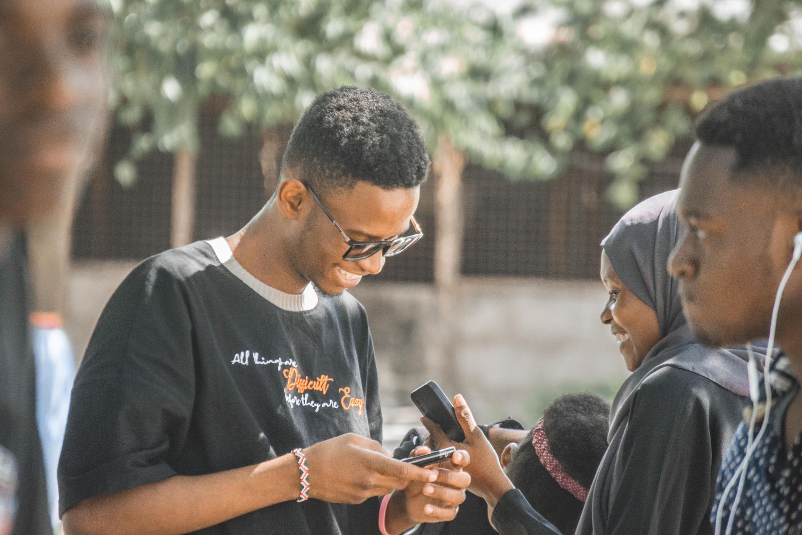 Jeunes consultant leurs téléphones en souriant