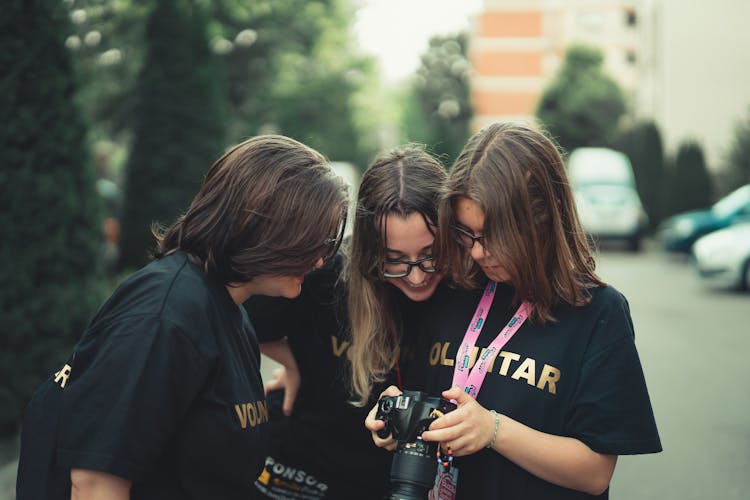 Women Wearing Black Crew Neck T-shirts Looking At The Black Camera 