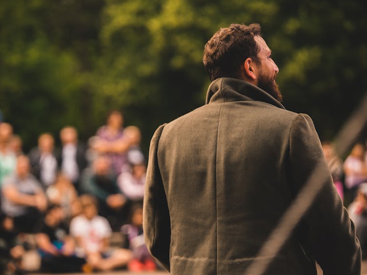 Man In Black Jacket Standing In Front Of People