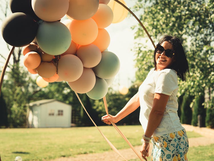 Smiling Woman With Balloons In Garden